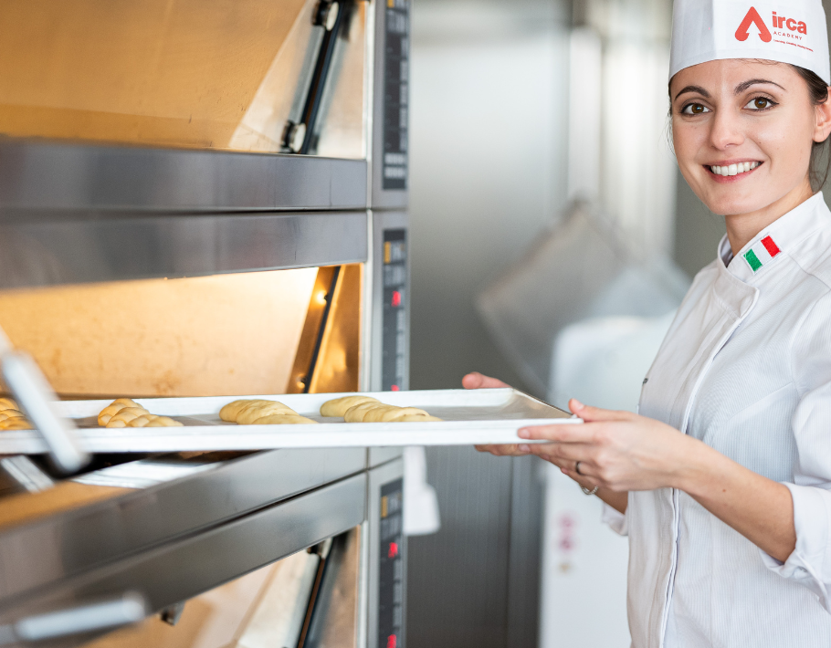 irca since - corporate chef placing croissants in the oven